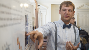 Biophysics research poster presented by graduate student in bow tie and suspenders